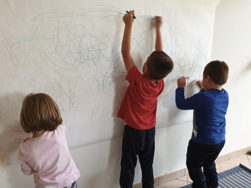Bambini che disegnano sulla lavagna - attività grafo-gestuali
